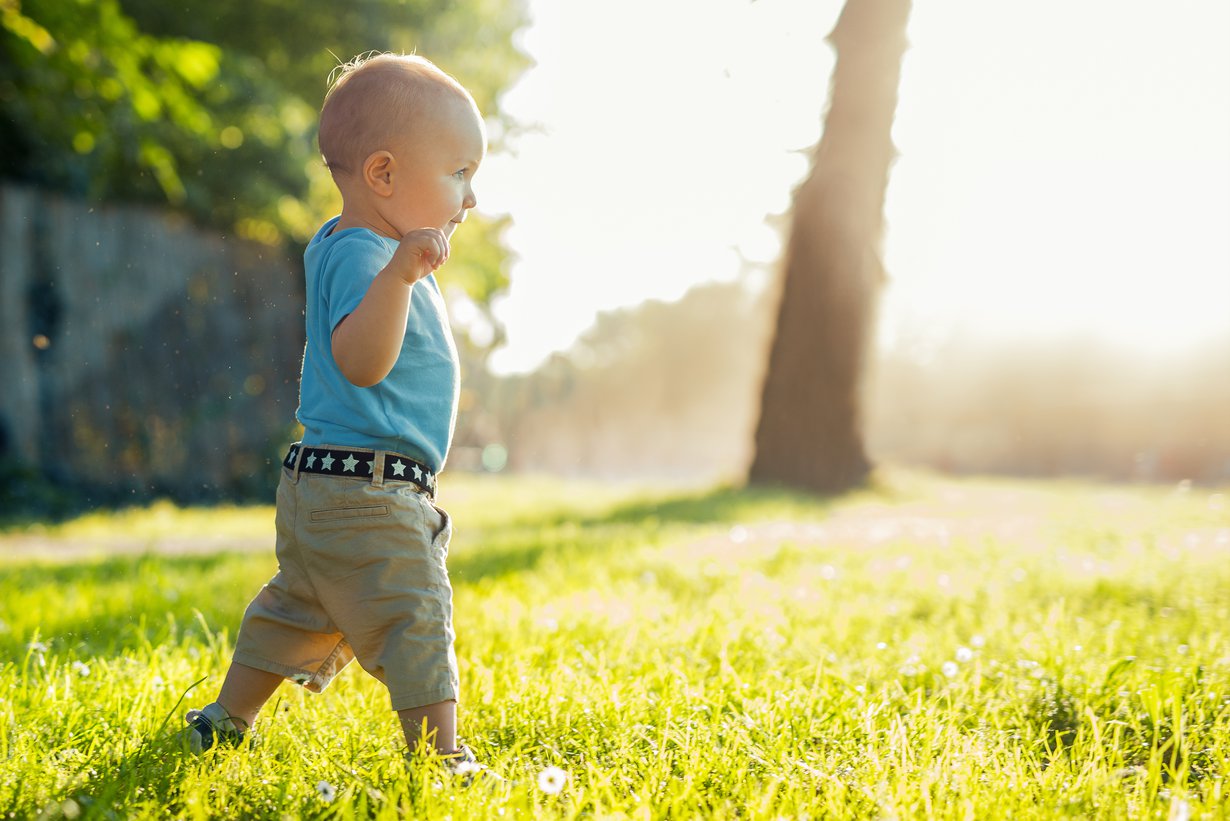 Alussa taapero tarvitsee käsiään tasapainon ylläpitämiseen. Nurmikolla pienet muksahdukset eivät onneksi haittaa! Kuva: iStockphoto