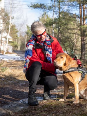Outi Lehtinen kulkee suojalasit päässä satoi tai paistoi. Lisäturvaa tuo valkoinen keppi ja opaskoira Ciru.