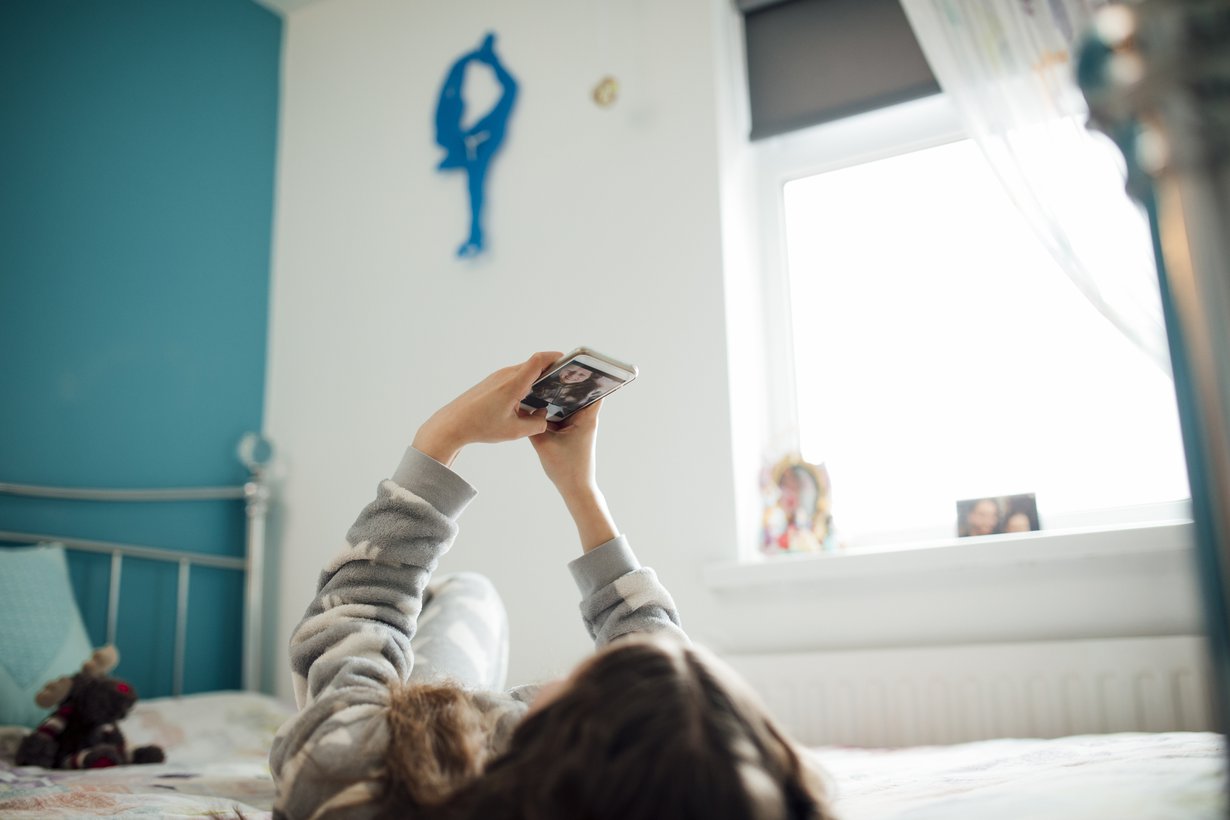 Puhelimeen on helppo turvautua, kun on tylsää. Puhu lapsen kanssa puhelimen käytöstä avoimesti, myös somemaailmasta. Kuva: iStockphoto