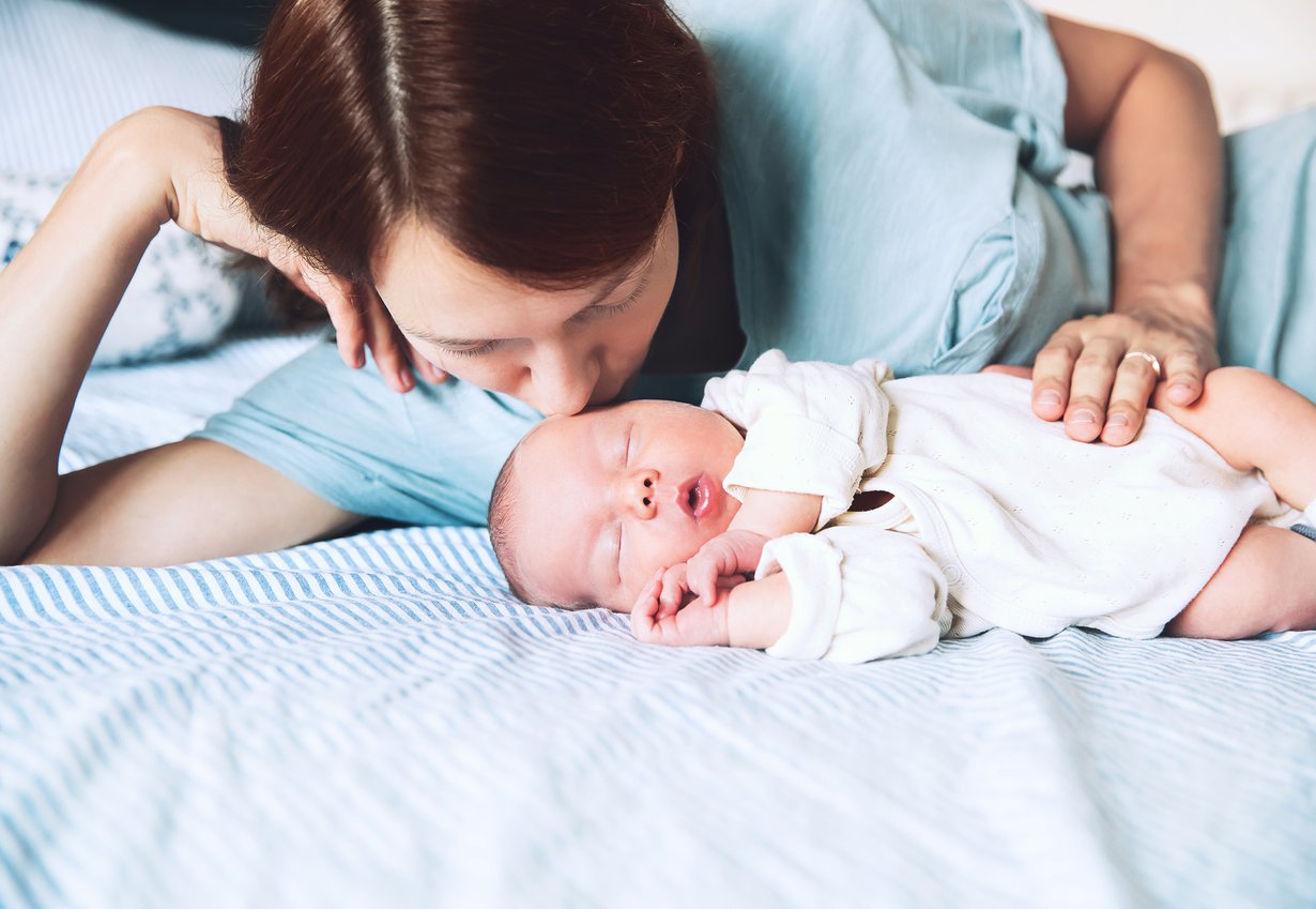 Pieni vauva nukkuu turvallisesti pelkällä patjalla, kasvot vanhemman kasvojen korkeudella. Kuva: iStockphoto