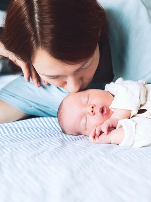 Pieni vauva nukkuu turvallisesti pelkällä patjalla, kasvot vanhemman kasvojen korkeudella. Kuva: <span class="photographer">iStockphoto</span>