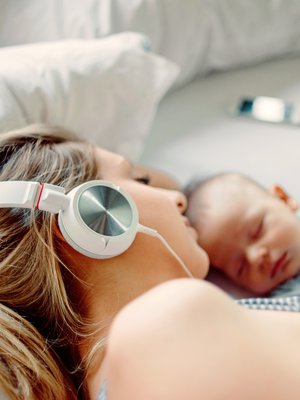 Vauva-arjessa äänikirja on hyvä vaihtoehto fyysisen kirjan rinnalle. Äänikirjaa voi kuunnella vaikka vauvan nukkuessa – ja lepuuttaa samalla itsekin silmiä. Kuva: <span class="photographer">iStock</span>